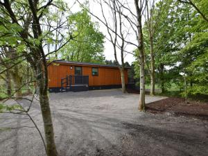 Una pequeña cabaña naranja en medio de los árboles. en 1 Bed in Langbank 73846, en Langbank