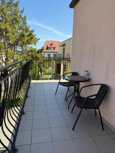 a patio with two chairs and a table on a balcony at Dom Wczasowy Mateusz in Rewal