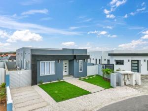 a modern house with a backyard with a lawn at New - 3br Private Villa Pool, Bbq & Comfort in Noord