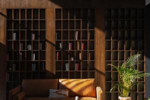 a library with a couch in front of a wall of books at Casa Mädi Hotel Boutique in Bernal