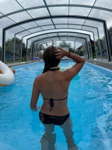 a woman is standing in a swimming pool at Domek Harmony Park in Kondrajec