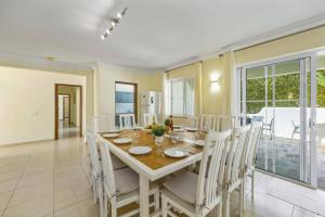 ヴァーレ・ド・ローボにあるVilla Canas by Villa Plusのテーブルと椅子のあるキッチンとダイニングルーム