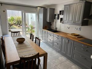 a kitchen with a table and a dining room at Causeway Beach House in Portrush