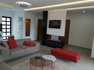 a living room with a couch and a red chair at Les Flots D'ezzahra in Ḩammām al Ghazzāz
