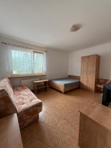 a living room with a bed and a couch at Dom Wczasowy Mateusz in Rewal