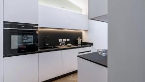 a kitchen with white cabinets and black counter tops at Chiaroscuro in Brescia