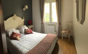 a bedroom with a white bed with red pillows at Tortuga in Dolus-d'Oléron