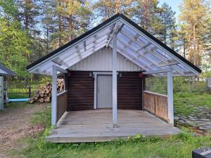 a small cabin with a porch and a wooden deck at Pirttiaitta in Oulu