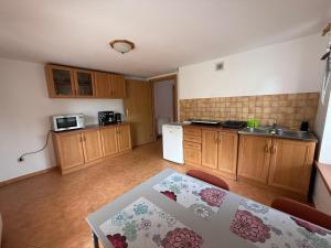 a kitchen with a table and a sink in it at Dom Wczasowy Mateusz in Rewal
