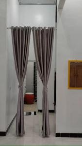 a pair of curtains in a room with a room at Naufal Homestay in Yogyakarta