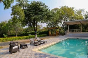 a swimming pool with chairs and a gazebo at Finca Nirvana. in Agua de Dios