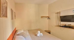 a bedroom with a bed with a flat screen tv at Matianellu Hostel in Rio de Janeiro