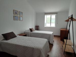 a hotel room with two beds and a window at Casa da Silveira in Angra do Heroísmo