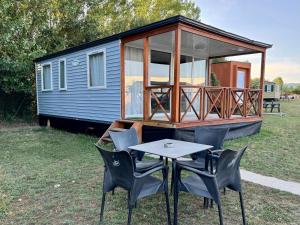 Una mesa y sillas frente a una pequeña casa. en La Villa del Karting, en El Teso