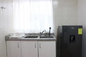 a kitchen with a sink and a refrigerator at Hospedaje la gran Tenochtitlán in San Martín Hidalgo +44 photos
