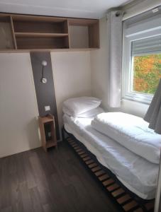 two beds in a room with a window at Mobil Home 3ch CONFORT Camping 4étoiles Les Charmettes 393 Proche FUN ZONE in Les Mathes +46 photos