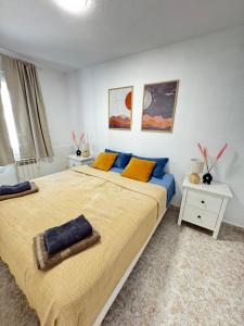 a bedroom with a large bed with yellow and blue pillows at Casa Salamanca La Mata in Torrevieja