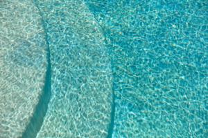 a close up of a bed with blue sheets at Mykonos Waves Beach House & Suites in Ornos