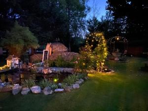 a garden at night with christmas lights and a pond at Ferienwohnung Landhausliebe in Zwiesel