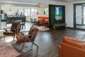 a living room with a table and chairs and a kitchen at Hotel Pommier Chariton in Chariton
