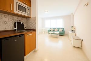 une cuisine avec un évier et un salon dans l'établissement Estudio Central Beach, à Estepona