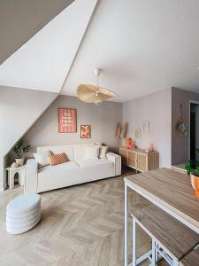 a living room with a white couch and a table at L'escale du Val in Pléneuf-Val-André