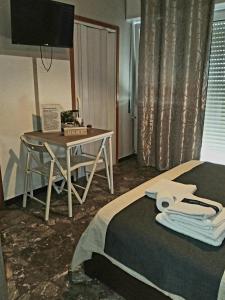 una habitación con una cama, un escritorio y un televisor en Casa Lella, en Policoro