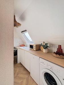 a kitchen with a washing machine and a skylight at L'escale du Val in Pléneuf-Val-André +10 photos