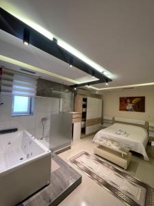 a bathroom with a tub and a bed and a sink at Jacuzzi Escape in Tirana