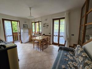 a living room with a couch and a table and a kitchen at Stella Alpina in Lizzola Alta