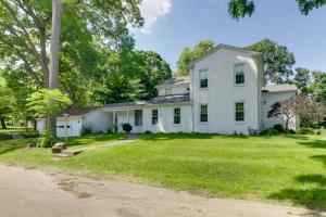 an exterior view of a white house with a large yard at Spacious and Updated Farmhouse in Yellow Springs in Fairborn