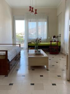 een slaapkamer met een bed, een tafel en een bank bij Sunset apartment Saronida by the sea with stunning view in Saronida