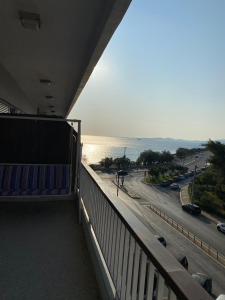 een balkon van een gebouw met uitzicht op de oceaan bij Sunset apartment Saronida by the sea with stunning view in Saronida
