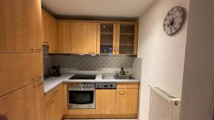 a kitchen with wooden cabinets and a sink and a clock at Altstadt Perle in Limburg an der Lahn