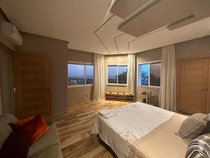 ein Schlafzimmer mit einem Bett und einer Couch und Fenstern in der Unterkunft Villa sur Tanger in Tangier + 38 Fotos