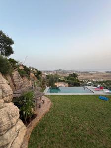 ein Hinterhof mit einem Swimmingpool und einer Felswand in der Unterkunft Villa sur Tanger in Tangier