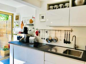 a kitchen with white cabinets and a sink at Studio avec jardin sud proche bord de mer in Sainte-Maxime
