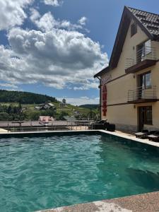 una piscina di fronte a un edificio di Villa Anet a Bukovel