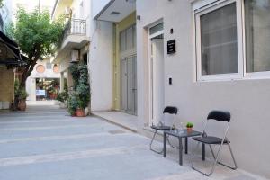 two chairs and tables on a sidewalk in an alley at Alexandras Urban Studio in Bendevís