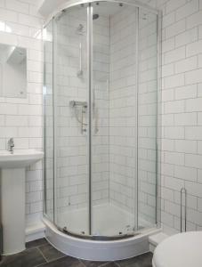 a shower with a glass door in a bathroom at City breaks Corby Double ensuites in Rockingham