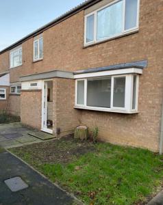 a brick house with a large window at City breaks Corby Double ensuites in Rockingham