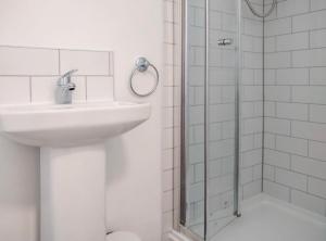 a white bathroom with a sink and a shower at City breaks Corby Double ensuites in Rockingham