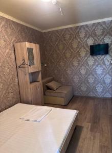 a small room with a bed and a chair at Amio more in Odesa