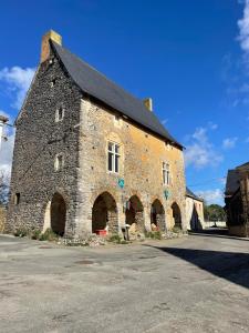 a large stone building with a black roof at La maison du clocher in Chéméré-le-Roi