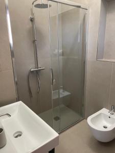 a bathroom with a glass shower and a sink at Villa Andrea in Rodello +7 photos