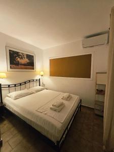 ein Schlafzimmer mit einem Bett mit zwei Handtüchern darauf in der Unterkunft Corfu Glyfada Menigos Resort 24 in Pelekas