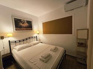 ein Schlafzimmer mit einem Bett mit Handtüchern darauf in der Unterkunft Corfu Glyfada Menigos Resort 24 in Pelekas + 41 Fotos