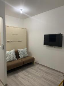 a living room with a couch and a flat screen tv at Studio cosy et indépendant - idéal pour 2 personnes in Dompierre-sur-Yon