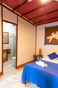 a bedroom with a bed and a bathroom at Pousada Cabanas Paraiso in Angra dos Reis
