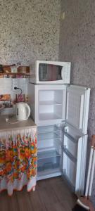 una cucina in miniatura con frigorifero e microonde di Гостевой дом Уют a Karolino-Buhaz Altre 28 foto